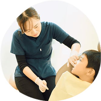 小児矯正患者の歯並びを確認する女性歯科医師｜小児矯正は矯正認定医と連携