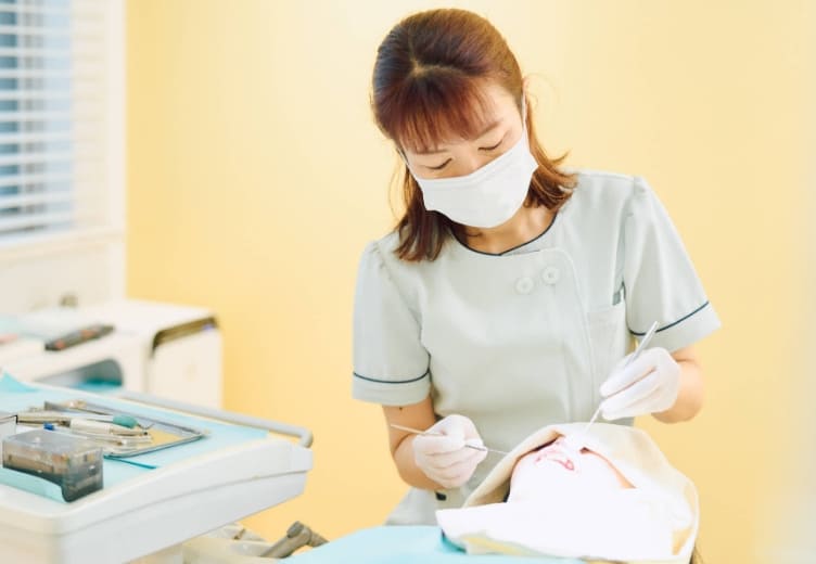 患者の歯のクリーニングをする歯科医師｜保険で歯のクリーニングが可能です